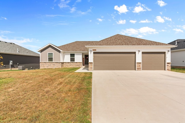 view of front of home featuring a front lawn, central AC, and a garage