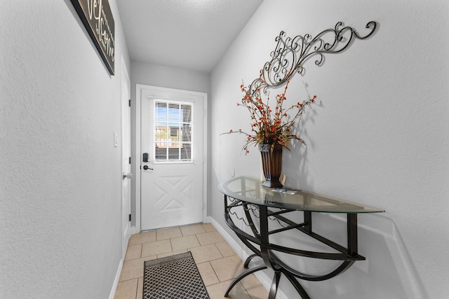 entryway featuring a textured ceiling and light tile patterned flooring