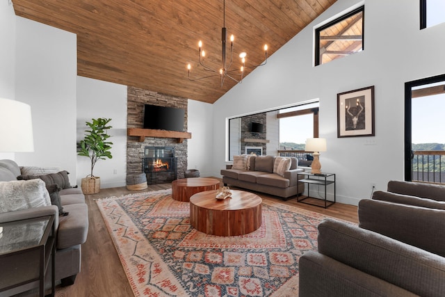 living room featuring high vaulted ceiling, hardwood / wood-style flooring, wooden ceiling, a notable chandelier, and a fireplace