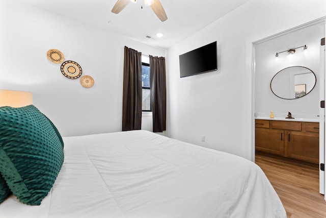 bedroom with ceiling fan, light hardwood / wood-style flooring, and ensuite bathroom