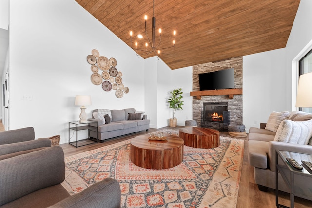 living room featuring wooden ceiling, high vaulted ceiling, hardwood / wood-style floors, and a stone fireplace