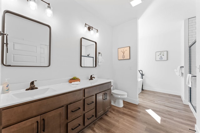 full bathroom with hardwood / wood-style floors, vanity, separate shower and tub, and toilet