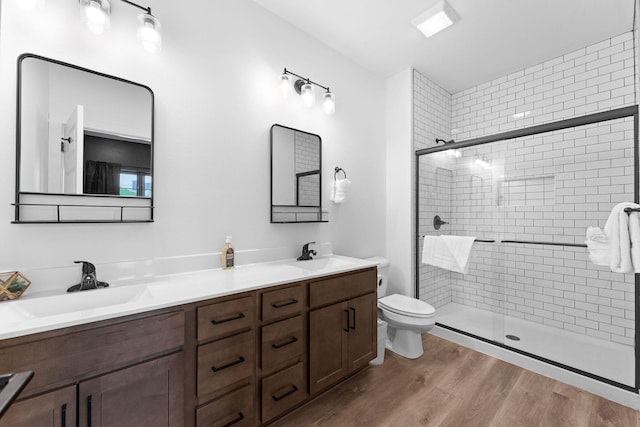 bathroom featuring hardwood / wood-style flooring, vanity, walk in shower, and toilet