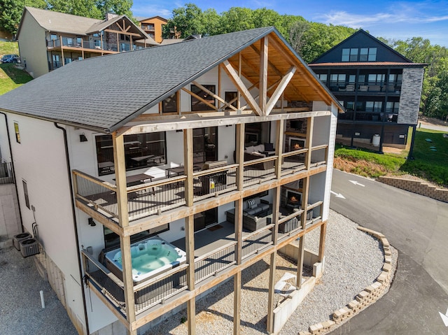 rear view of property featuring a hot tub