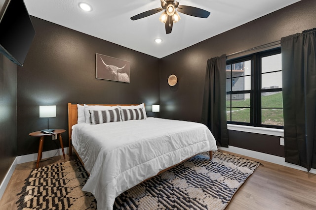 bedroom featuring light hardwood / wood-style flooring, multiple windows, and ceiling fan