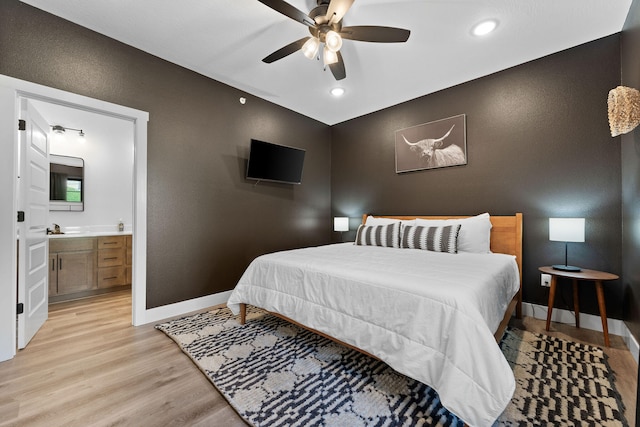 bedroom with sink, ceiling fan, connected bathroom, and light hardwood / wood-style flooring