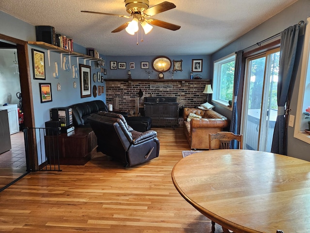 living room featuring light hardwood / wood-style floors, a textured ceiling, and ceiling fan