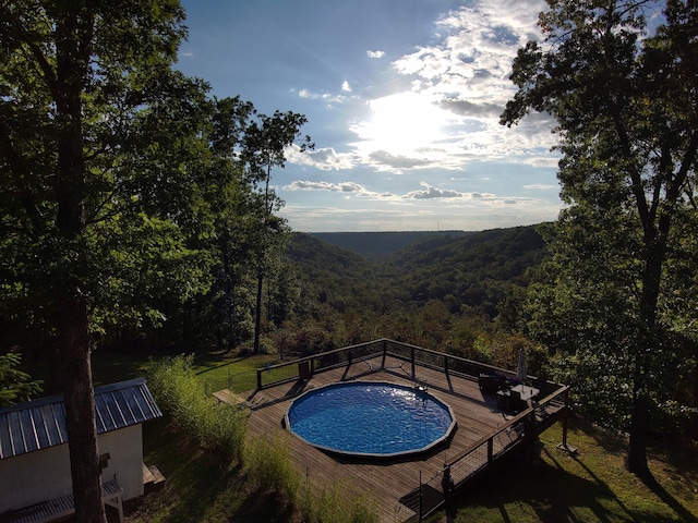 view of swimming pool with a deck with mountain view