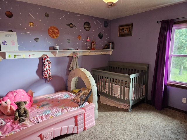 bedroom featuring carpet flooring, a textured ceiling, and a crib