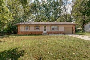 single story home with a front yard and a garage