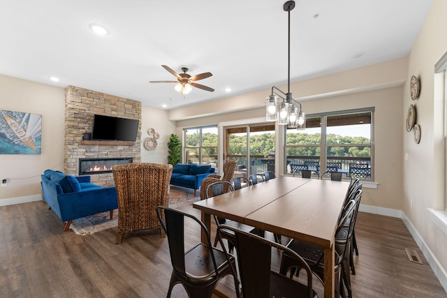 dining space with ceiling fan, a fireplace, plenty of natural light, and dark hardwood / wood-style flooring