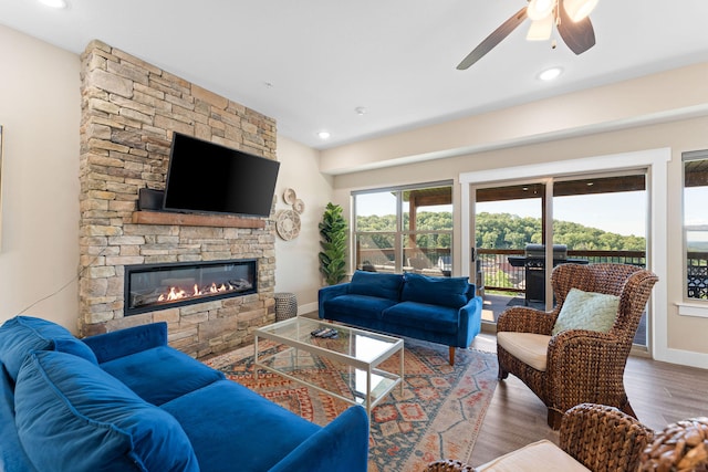 living room with hardwood / wood-style flooring, a fireplace, and ceiling fan