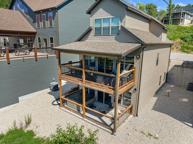 rear view of house featuring central air condition unit, a patio, a sunroom, and a deck