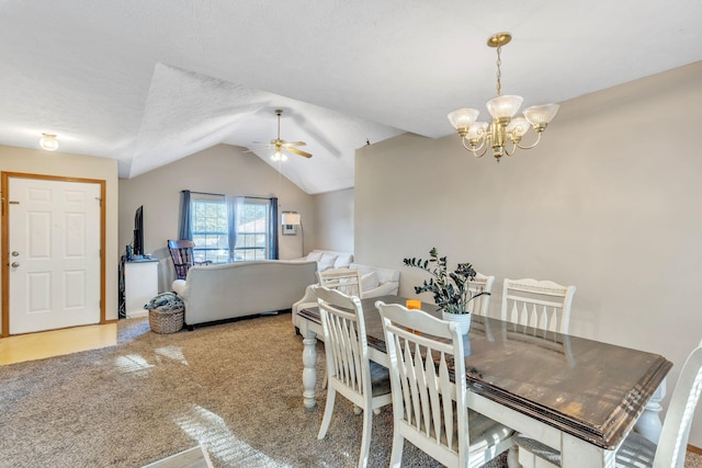 carpeted dining room featuring a textured ceiling, vaulted ceiling, and ceiling fan with notable chandelier