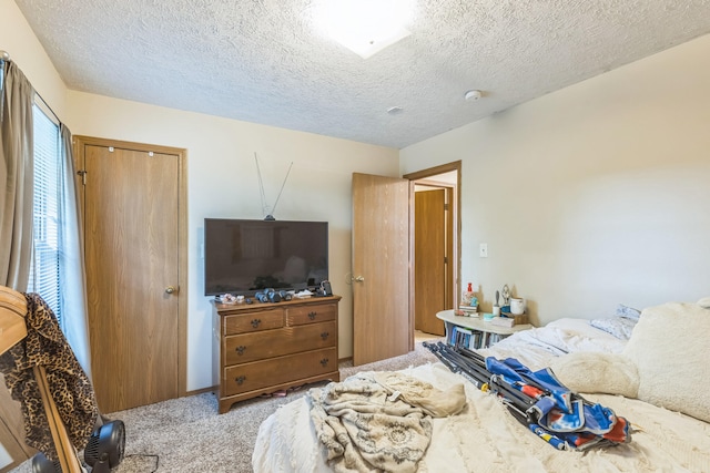 carpeted bedroom with a closet and a textured ceiling