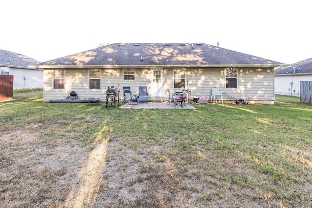 back of property featuring a patio area and a lawn