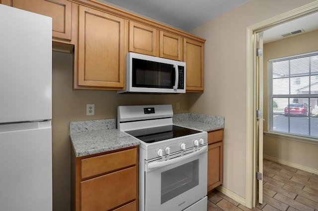 kitchen with visible vents, baseboards, and white appliances