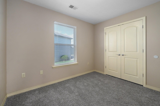 unfurnished bedroom with a closet, visible vents, carpet flooring, and baseboards