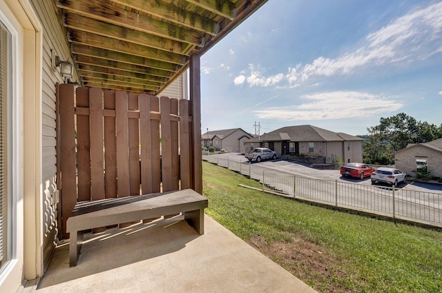 view of patio with fence and a residential view
