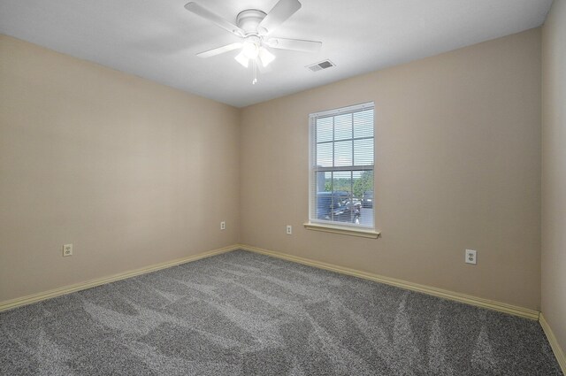 empty room featuring baseboards, visible vents, carpet, and ceiling fan