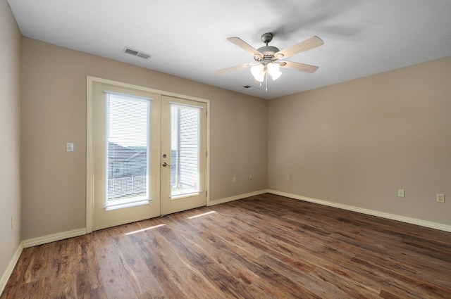 spare room featuring wood finished floors, visible vents, french doors, baseboards, and ceiling fan