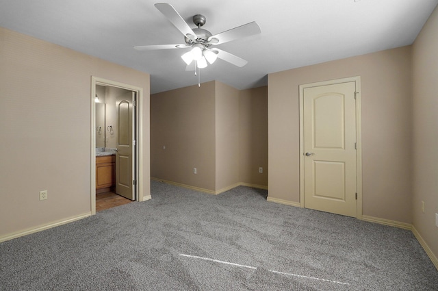 unfurnished bedroom with baseboards, ensuite bath, light colored carpet, and ceiling fan