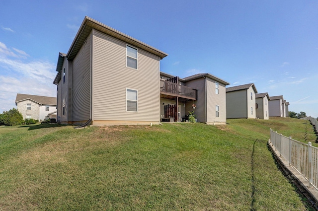 back of house featuring a wooden deck, fence, and a yard