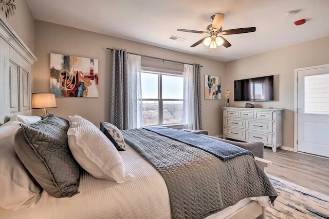 bedroom with light hardwood / wood-style floors and ceiling fan