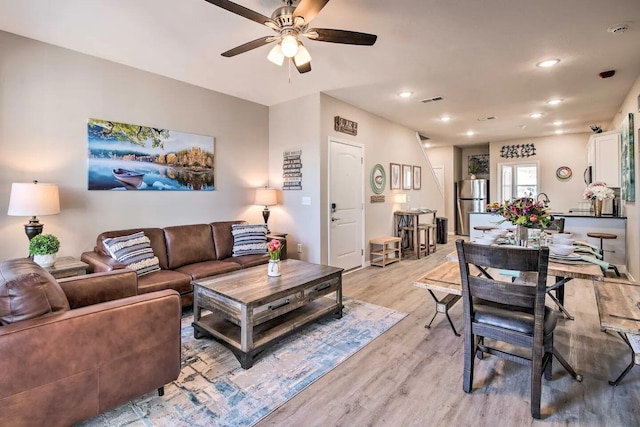 living room with light hardwood / wood-style floors and ceiling fan