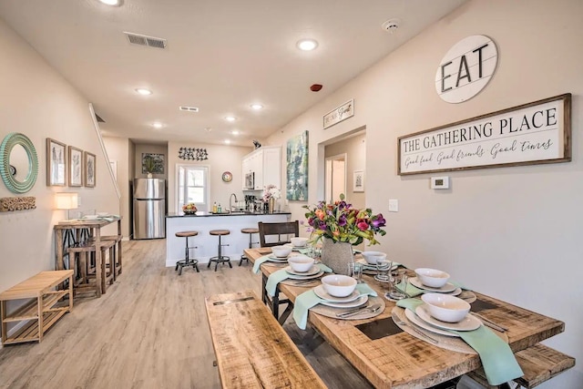 dining area with light hardwood / wood-style flooring and sink