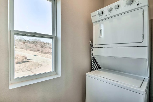 clothes washing area with stacked washer / dryer