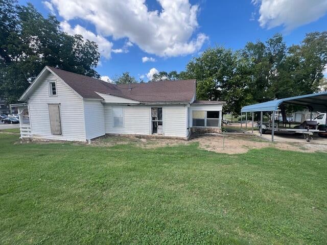 back of house with a yard and a carport