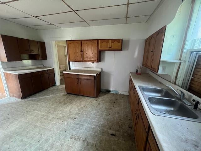 kitchen featuring a paneled ceiling, ventilation hood, and sink