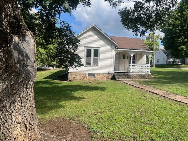 view of front of house featuring a front lawn and covered porch