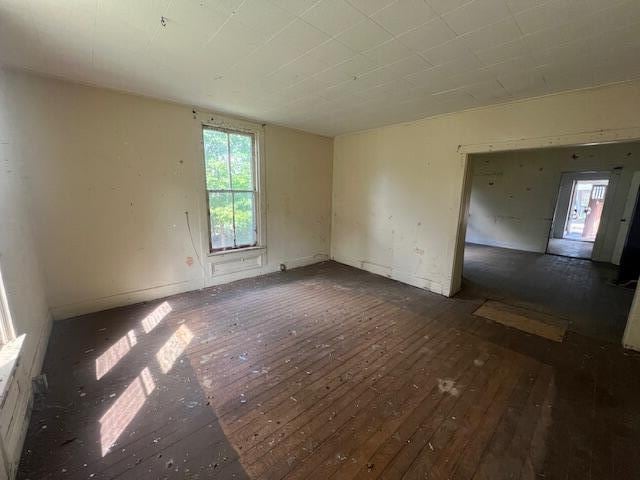 unfurnished room featuring a healthy amount of sunlight and dark hardwood / wood-style floors