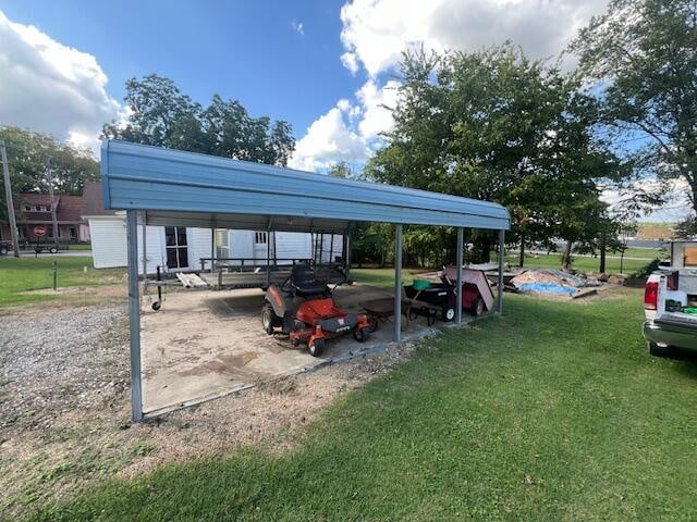 view of parking with a lawn and a carport