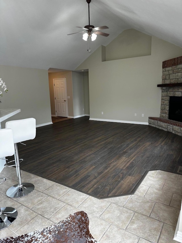 unfurnished living room with ceiling fan, a fireplace, and lofted ceiling