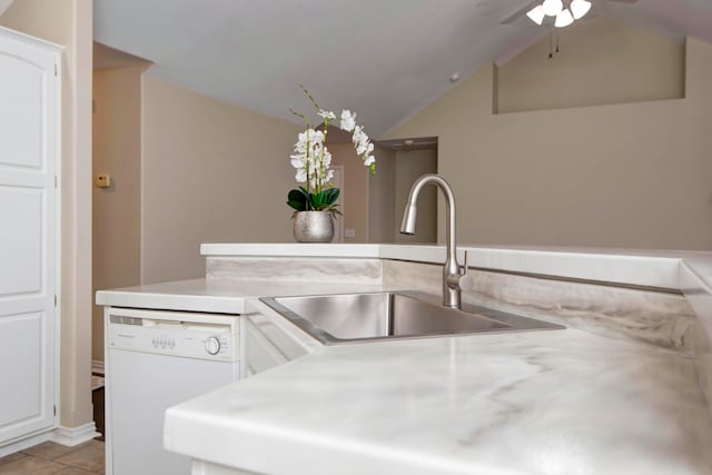 kitchen with lofted ceiling, white dishwasher, sink, light tile patterned flooring, and white cabinetry