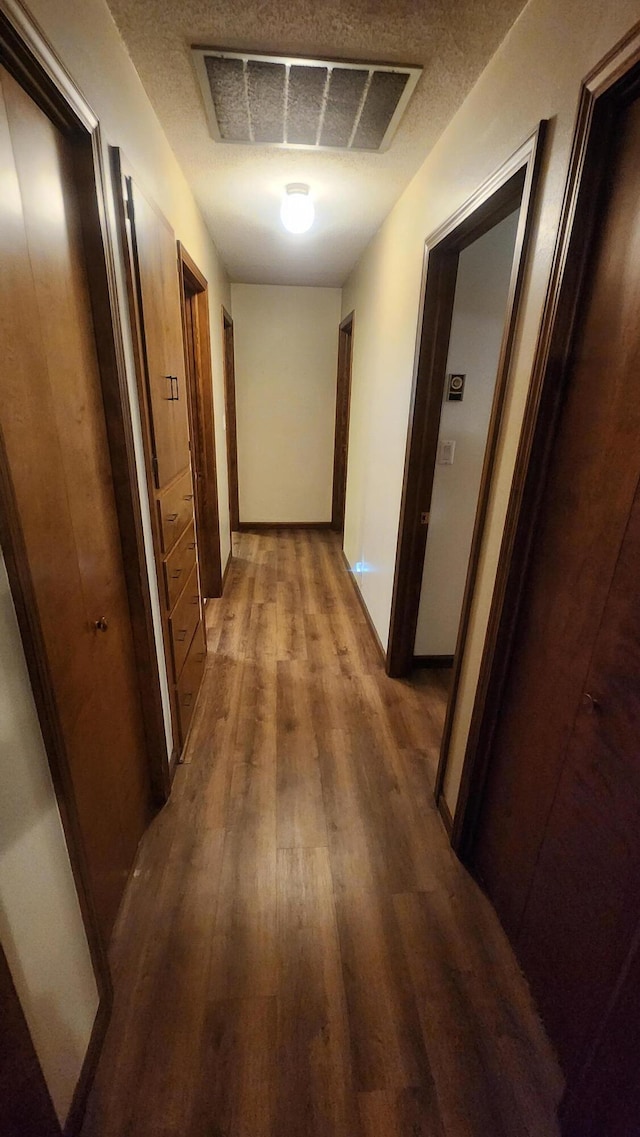 hall featuring hardwood / wood-style flooring and a textured ceiling