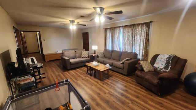 living room featuring dark hardwood / wood-style flooring, a textured ceiling, and ceiling fan