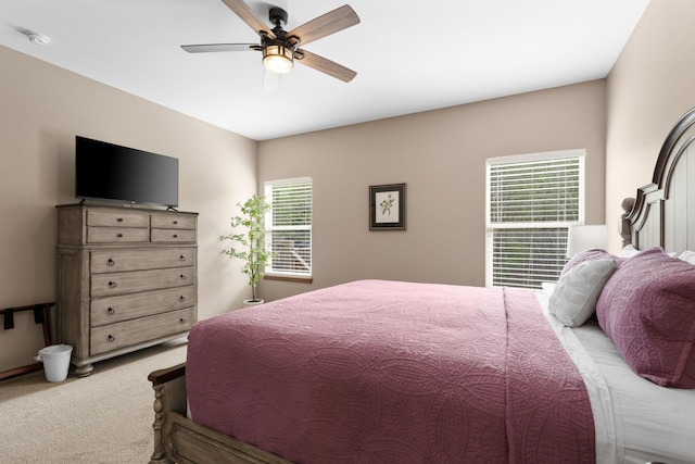 bedroom featuring light colored carpet, multiple windows, and ceiling fan