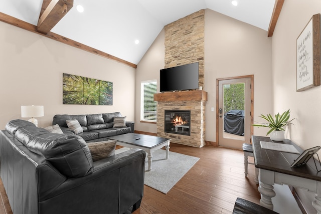 living room with high vaulted ceiling, a stone fireplace, and wood-type flooring