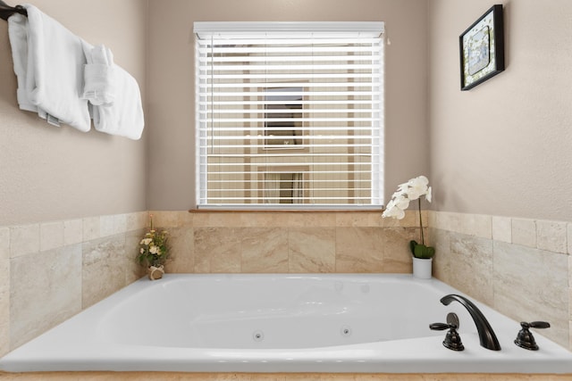 bathroom with a tub with jets