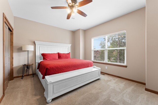 carpeted bedroom featuring a closet and ceiling fan