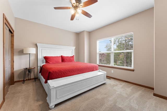 bedroom with light carpet, a ceiling fan, and baseboards