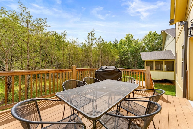 wooden deck featuring outdoor dining area and a grill