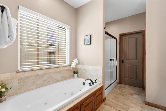 bathroom featuring a shower stall and a jetted tub