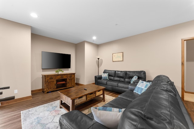 living room featuring baseboards, wood finished floors, and recessed lighting