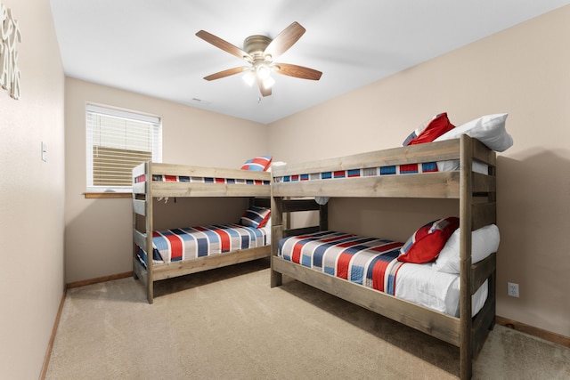 carpeted bedroom with ceiling fan and baseboards