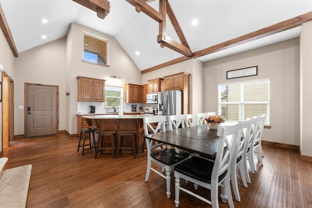 dining room featuring dark hardwood / wood-style flooring, high vaulted ceiling, and a healthy amount of sunlight